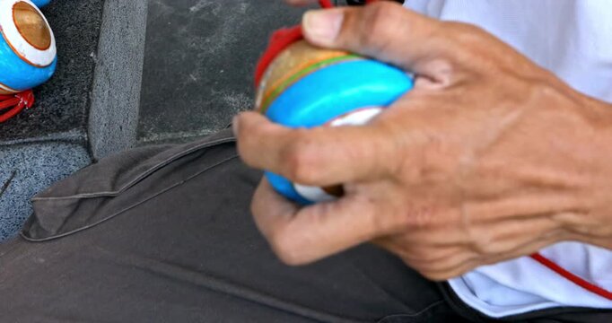 Masterful Display of Traditional Wooden Spinning Tops in Hand
