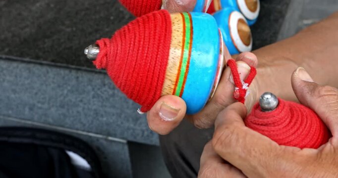Masterful Display of Traditional Wooden Spinning Tops in Hand