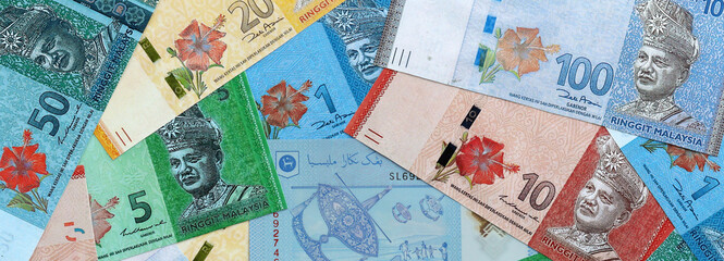 Malaysian ringgit money banknotes pile on table. Malaysia bills of MYR currency close up © Larysa