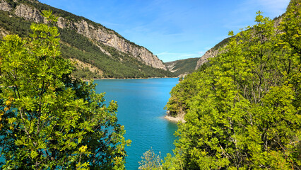 Lake Castillon's turquoise water winding through mountains and lush green trees, Alpes-de-Haute-Provence, France, Europe. © Iryna Shpulak