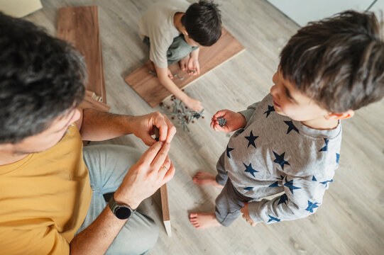 Father and children assembling furniture together at home