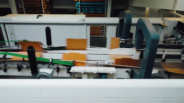 Automated packaging workflow. Robotic systems for factories. Manufacturing line utilizing robotic folding and sealing. Production process featuring conveyor automation and robotic handling
