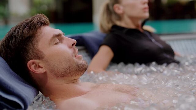 Couple doing ice bath at a luxury wellness retreat, practicing deep breathing to enhance cold therapy benefits, embracing mindfulness, biohacking, holistic recovery, and longevity in a serene setting