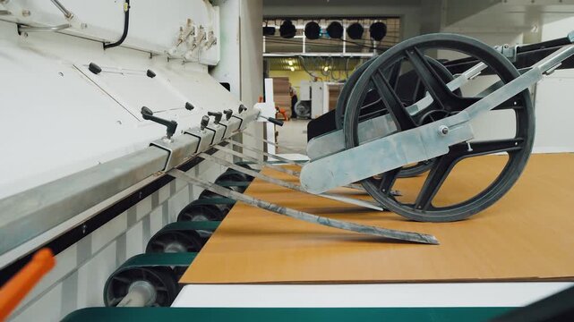 Automation device smoothly manages cardboard through manufacturing process. Robust rotating wheel movement ensures accurate positioning of packaging cardboard in factory production