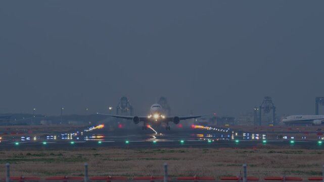 夜の滑走路から飛び立つ飛行機