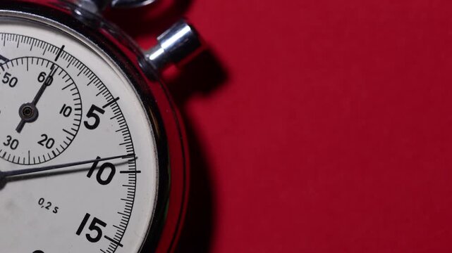 stopwatch placed on a red background with visible ticking hands and clear copy space for text,  time measurement, countdown, and classic precision, copy space