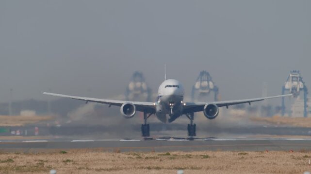 陽炎が立ち上がる滑走路から離陸する飛行機