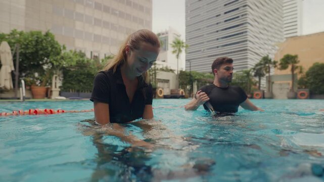 Two people doing aqua biking in a pool at a modern wellness center, engaging in low-impact cardio, hydrotherapy, and mindful fitness, blending luxury wellness, active recovery, and holistic health tre