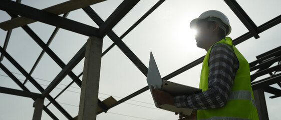 inspector or engineer is inspecting construction and quality assurance new house using computer. Engineers or architects or contactor work to build the house before handing it over to the homeowner