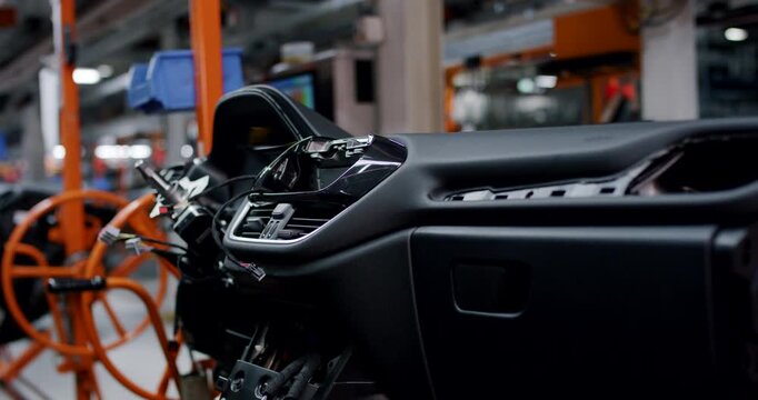 Close up of a modern car dashboard assembly during the manufacturing process in an automotive factory