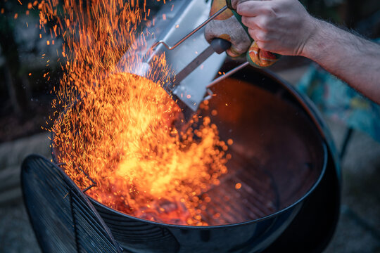 Close up on braces inside a BBQ ready to cook, sparks are visible.