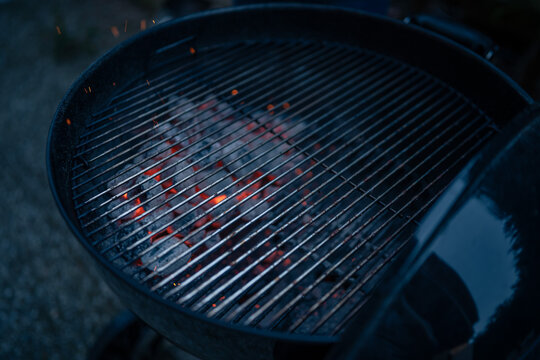 Close up on braces inside a BBQ ready to cook, sparks are visible.