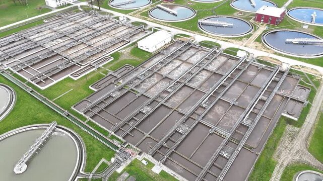 Aerial view of municipal wastewater treatment plant showing multiple circular tanks, filtration systems, and surrounding green areas, highlighting the infrastructure and operational layout of the faci