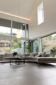 Curved gray sectional sitting centered in modern home, showing cushions and black coffee table