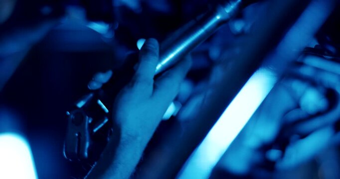 Close up of hand adjusting metal structural component in a dark industrial setting with blue light