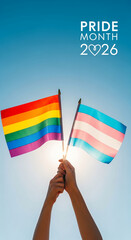 Fototapeta premium Two hands holding rainbow and transgender flags against a bright blue sky, celebrating Pride Month 2026, symbolizing equality and support