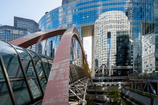 A modern bridge frames glass office skyline and corporate business finance architecture at La Defense Paris forming an urban connection within a financial district