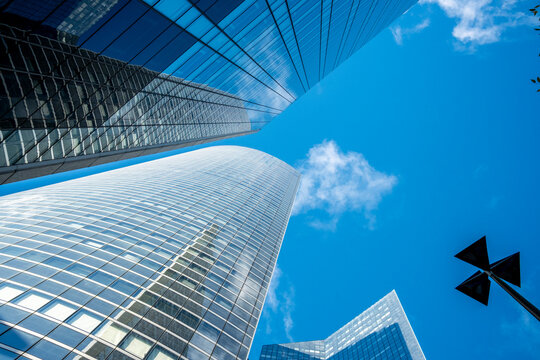 Glass skyscraper architecture for corporate business finance creates dramatic perspective and geometry within the skyline at La Defense Paris modern office district