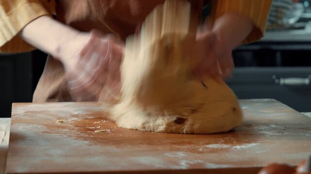 Woman in apron mixing raisin dough for Easter bread in home kitchen