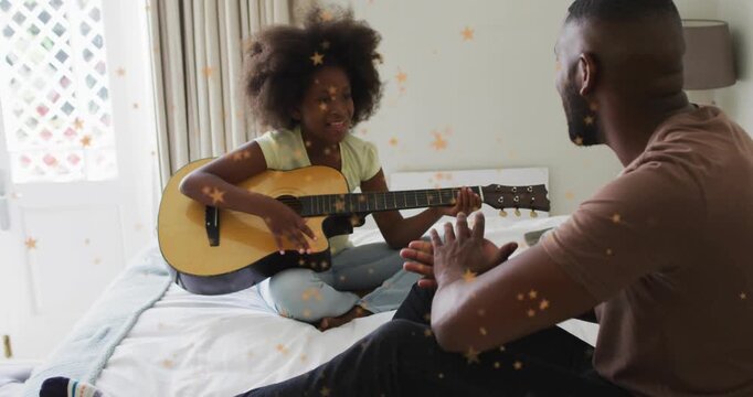 Child placing fingers on guitar neck, strumming while dad guiding, star overlays aiding practice