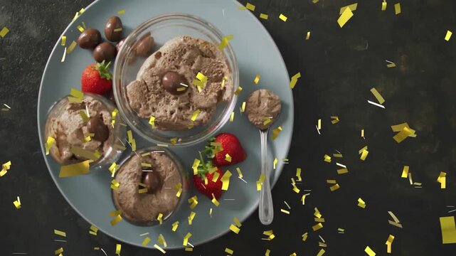 Vertical video: Gold confetti falling from right hiding plate choc bowls berries, revealing dessert