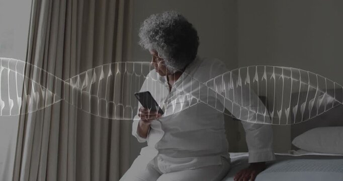 Senior woman shifting on bed scrolling phone reading health data while waveform fixed across frame