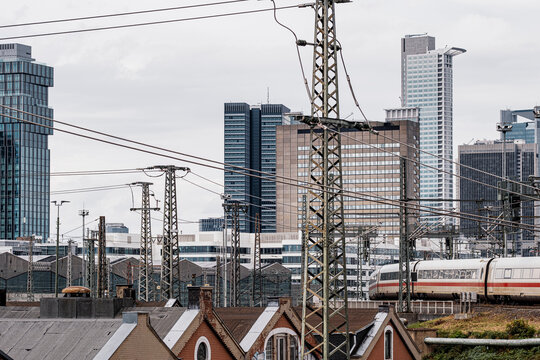 Railway tracks and wires cut across Frankfurt Germany as urban towers rise in the skyline highlighting transport infrastructure today