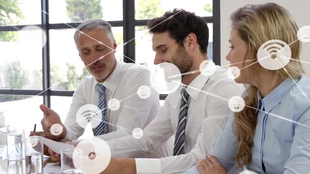 Mature man gesturing pen initiating network icons overlay while team reviewing papers, closing deal