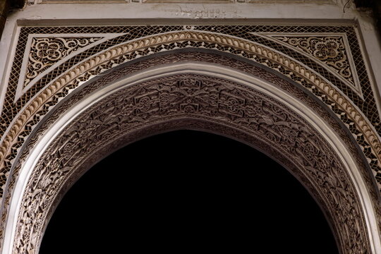 Richly carved stucco arch with floral and geometric motifs, doorway to a room in the gallery around the Small Riad-Bahia Palace. Marrakesh-Morocco-266