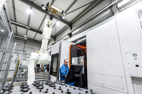 Maintenance engineer operating robotic machinery in modern manufacturing factory