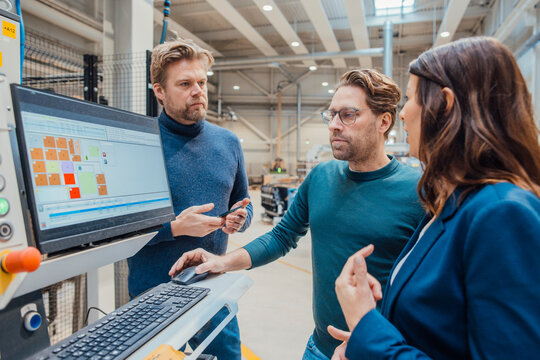 Business colleagues discussing over computer and working in industry