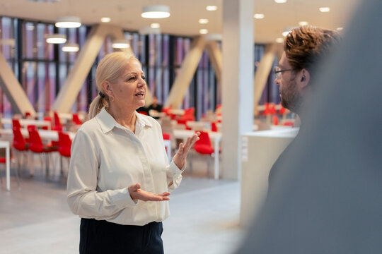 Senior businesswoman gesturing and discussing with colleague