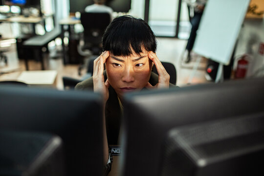 Stressed professional woman at computer in office