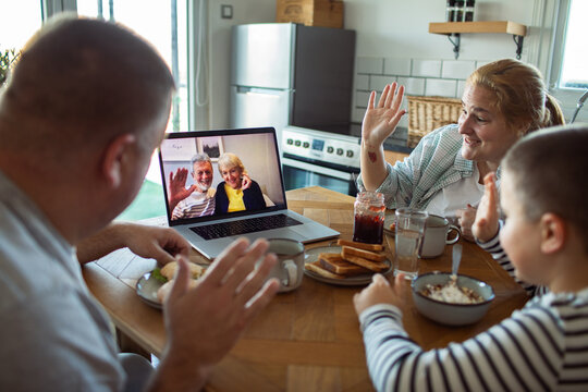 Family video call with grandparents during breakfast at home