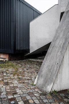 Industrial urban courtyard with concrete structure and container beside cobblestone ground creating minimalist geometry lines in modern space