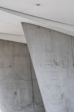 Abstract brutalist concrete architecture detail with angled beam and column showing raw texture and minimalist geometric structure background