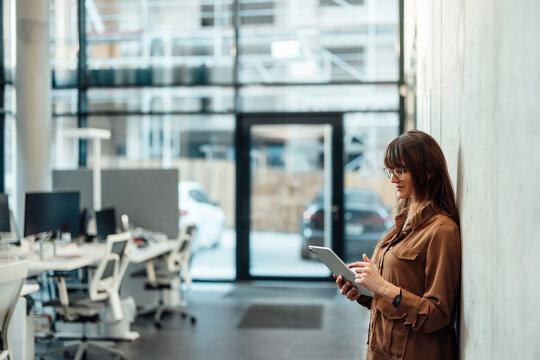 Businesswoman with tablet in modern office taking over company