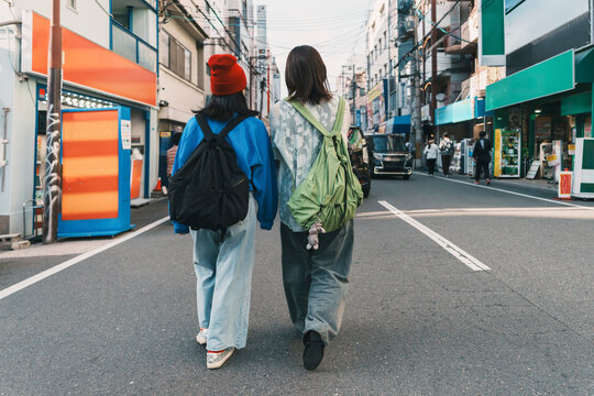 Friends with backpacks walking on a city street in Osaka