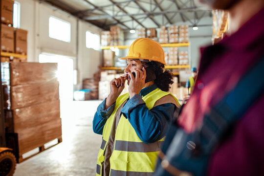 Warehouse supervisor on phone in busy distribution center