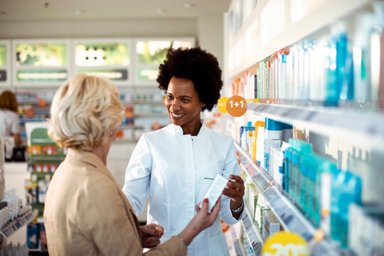 Pharmacist advising senior customer in pharmacy aisle