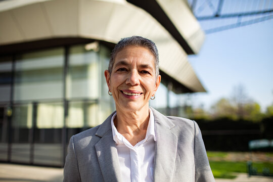 Confident senior businesswoman smiling outside office
