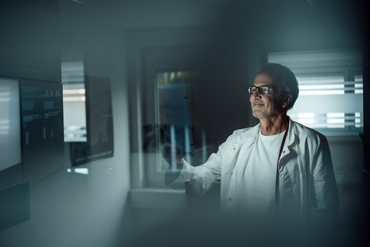 Doctor analyzing medical data with artificial intelligence at night