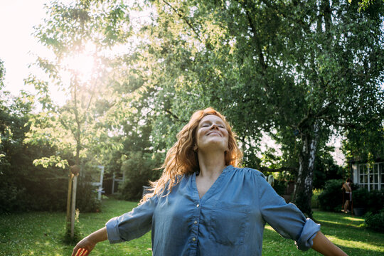Happy woman enjoying leisure time in back yard