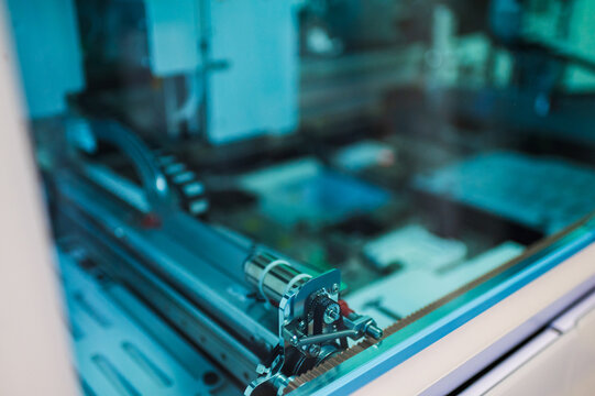 Closeup Conveyor Track And Precision Guide Rails Inside Automated Instrument, Teal Lighting Highlights