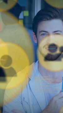 Vertical video: Office presenter uncrossing and holding pen for pitch as yellow icons sliding aside