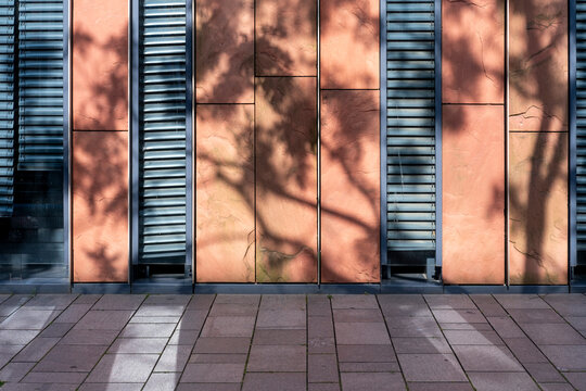 Daylight on urban wall facade panels forming shadow pattern and texture in a minimal abstract scene with ample copyspace for clean brand backgrounds