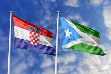 Fototapeta premium Croatia and Maakhir flags waving in a clear blue sky, symbolizing a powerful diplomacy, a strategic partnership, and a shared vision of unity for a sustainable future.