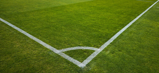 Naklejka premium Soccer Field Corner Markings and Playing Area with White Lines on a Natural Grass Field, featuring genuine natural grass.