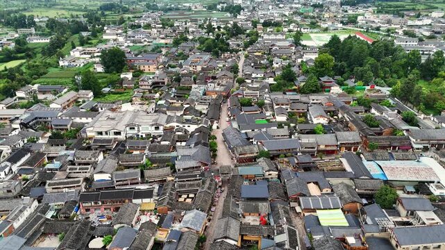 Baisha town traditional rooftops and narrow street pattern near Fuguo Monastery Yunnan, aerial tilt up backdrop
