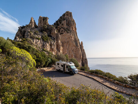Camper van parked on cliff road overlooking Baunei coastline